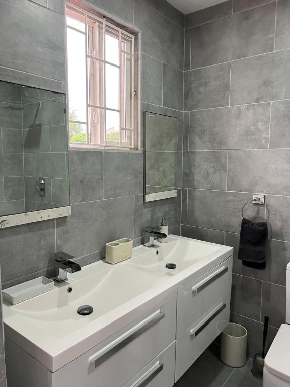 W łazience znajduje się biała umywalka i lustro. w obiekcie Belle Luxury Apartments w mieście Gros Islet