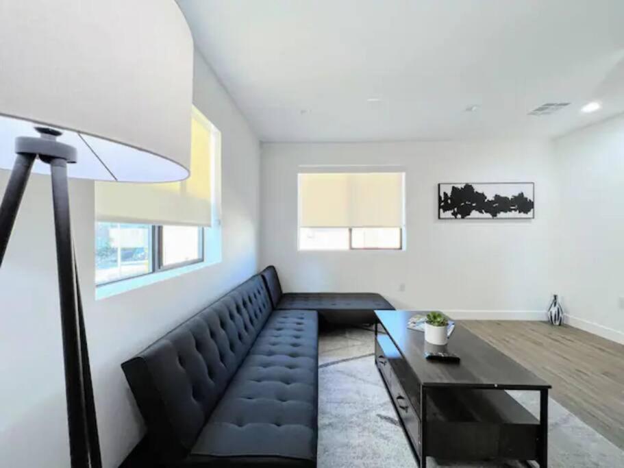 4BR Townhouse in KoreaTown في لوس أنجلوس: غرفة معيشة مع أريكة سوداء وطاولة
