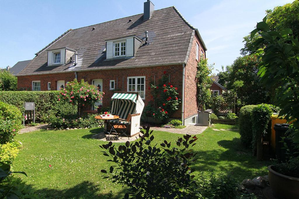 una casa in mattoni con tavolo e sedie nel cortile di App Anne a Süderende