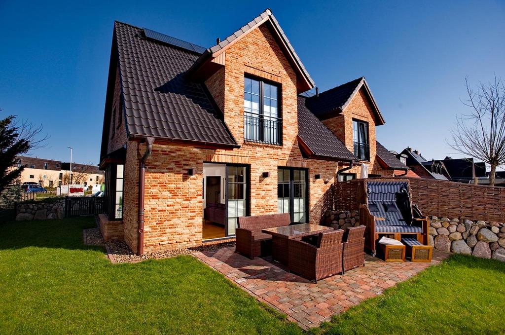 a brick house with two chairs and a table at Gode Stuv in Westerland