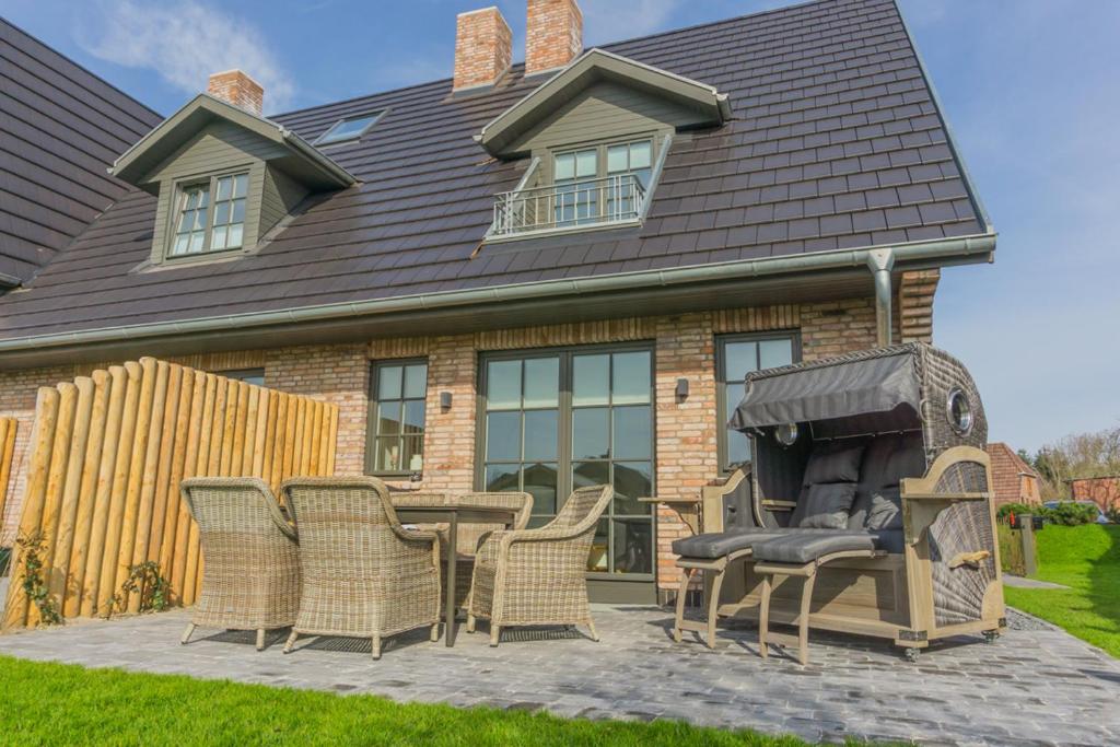 a patio with a table and chairs in front of a house at Hoogen Hüs in Westerland