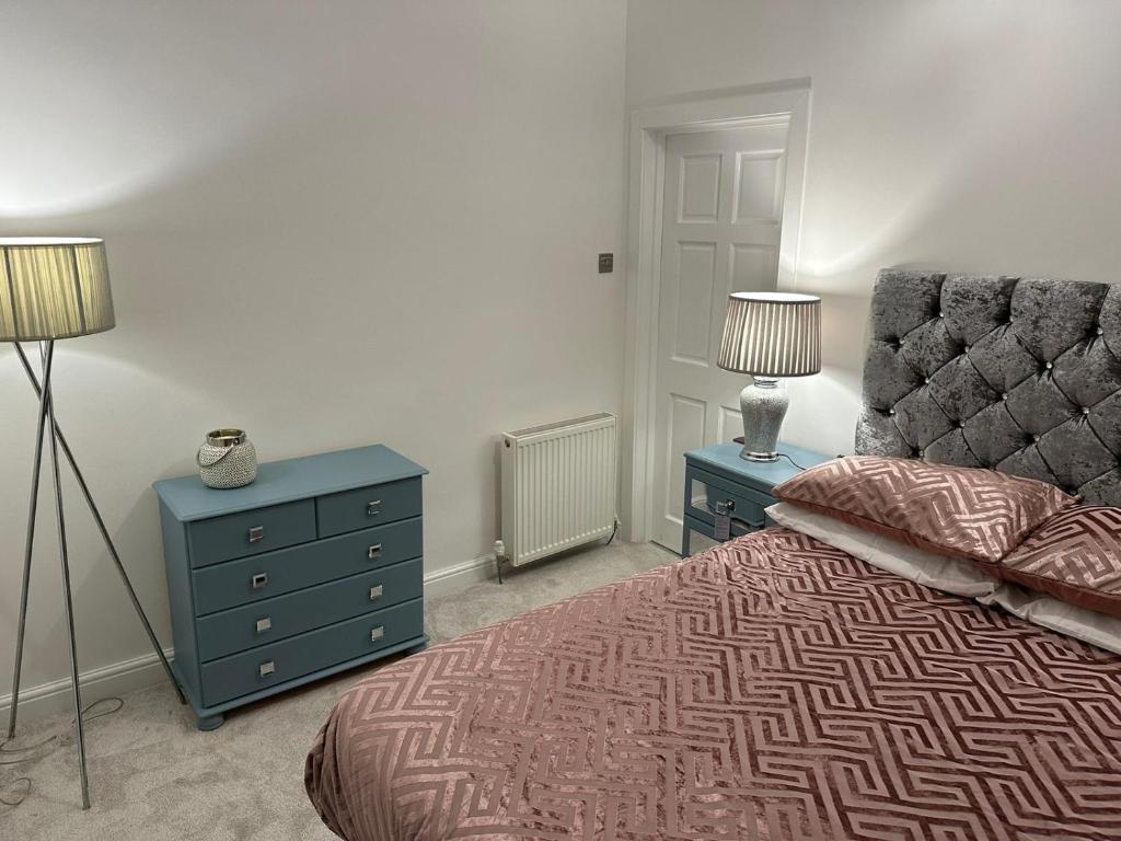 a bedroom with a bed and a dresser and two lamps at Amazing Getaways - The Place for You with Free Parking in Aberdeen