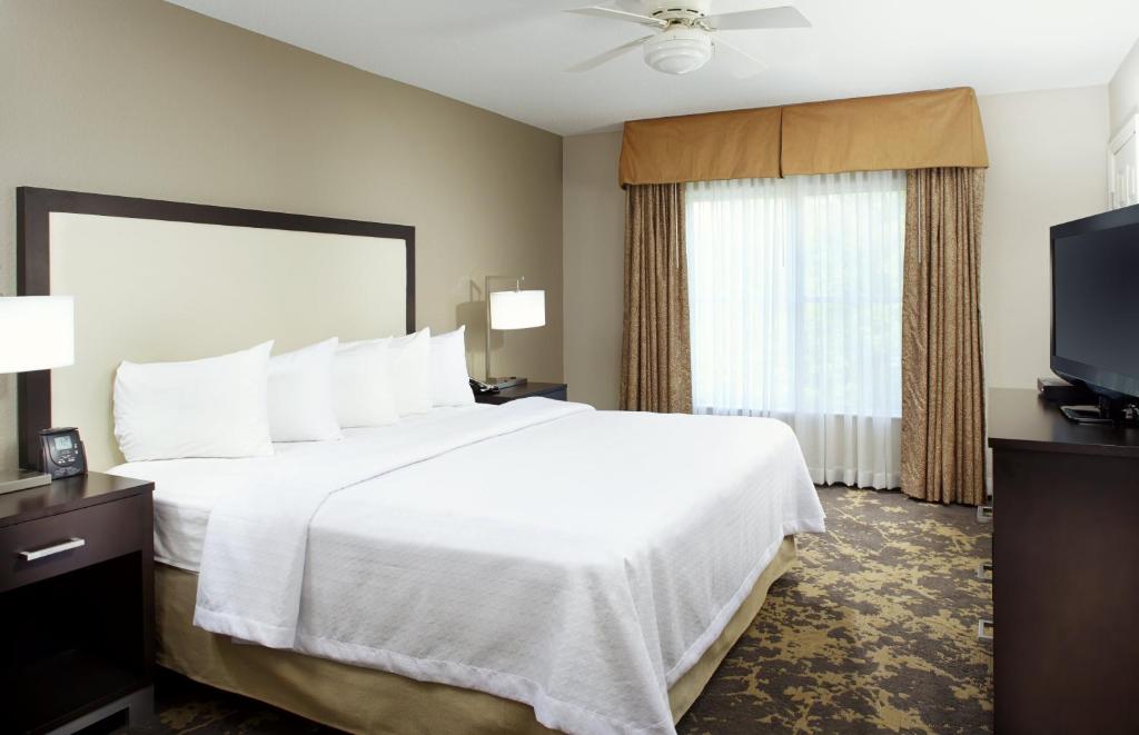 a hotel room with a large bed and a flat screen tv at Trellis Lake Pointe in Charlotte