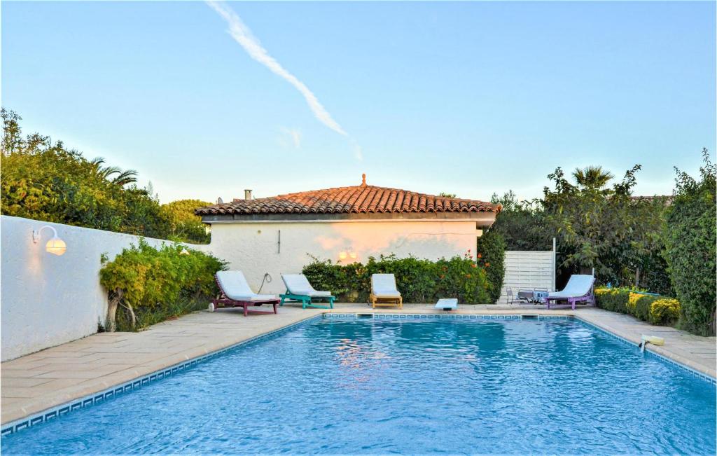 - une piscine avec des chaises et une maison dans l'établissement Beautiful Apartment In Sainte-maxime With Wifi, à Sainte-Maxime