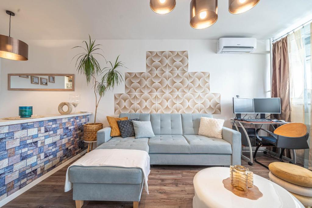 Pastelle Apartment with own parking place في بودابست: غرفة معيشة مع أريكة وطاولة