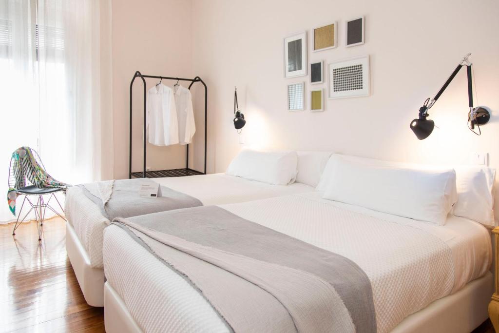 a white bedroom with a large bed and a window at SANMARTINA HOTEL in Becerril de Campos