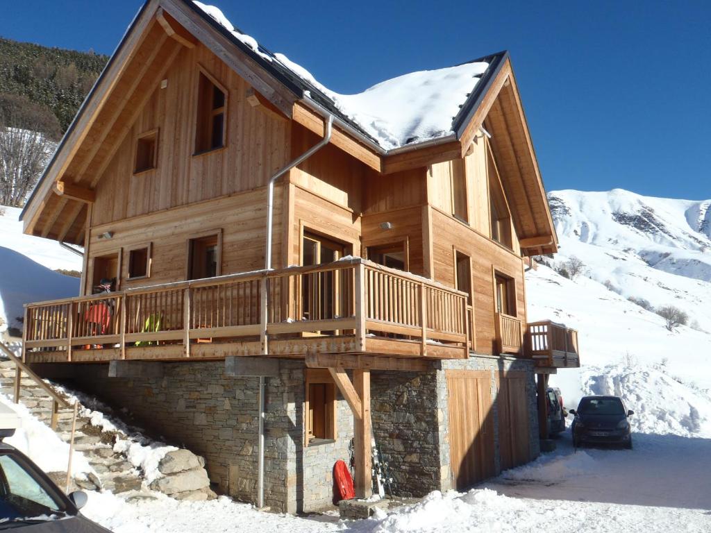 a log cabin with a balcony in the snow at Chalet La Ruche in Saint-Sorlin-dʼArves