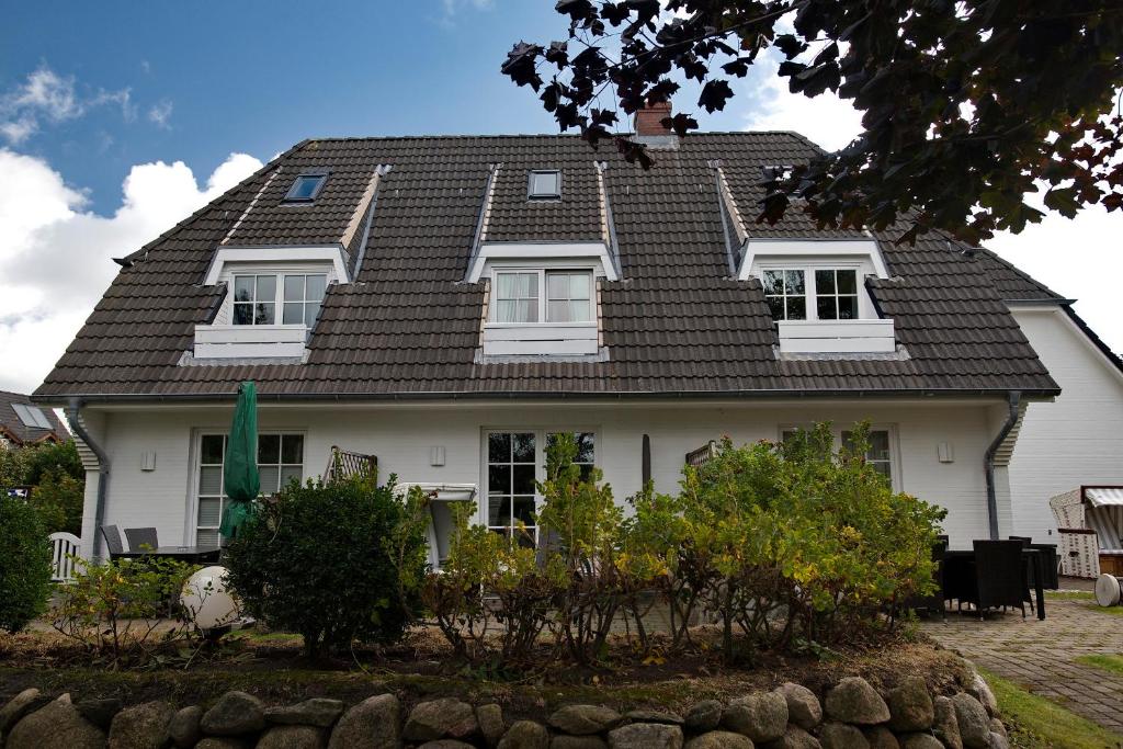 een wit huis met een zwart dak bij Witt Hingst App 10 in Tinnum