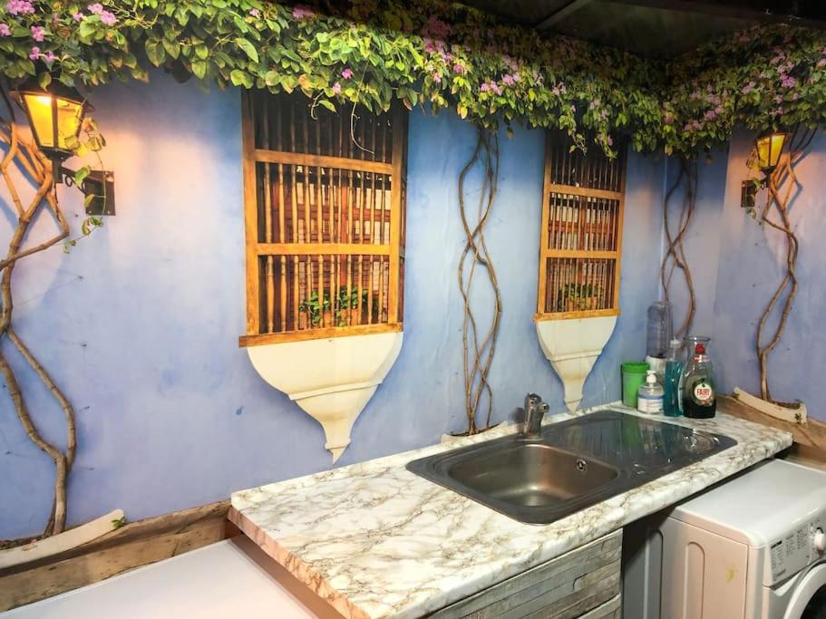 a kitchen with a sink and a blue wall at Cheerful 4 bedroom house with garden free parking in London