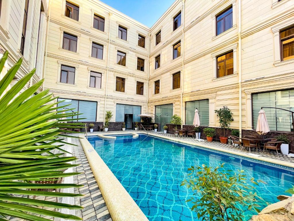 Medina Hotel Samarkand في سمرقند: مسبح امام مبنى