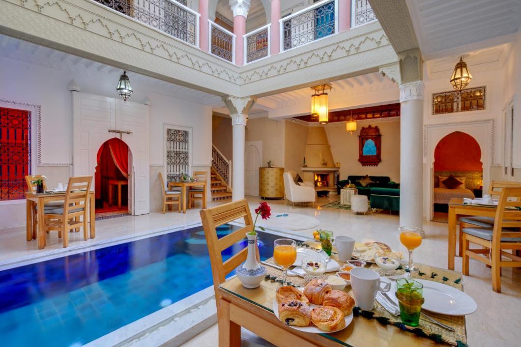 une villa avec une piscine et une salle à manger dans l'établissement Samira Group & Spa, à Marrakech