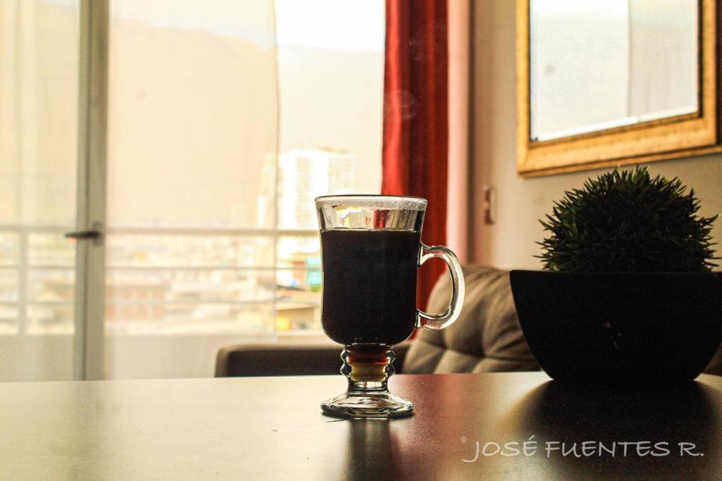 a glass of wine sitting on top of a table at Edificio Bulnes Iquique in Iquique