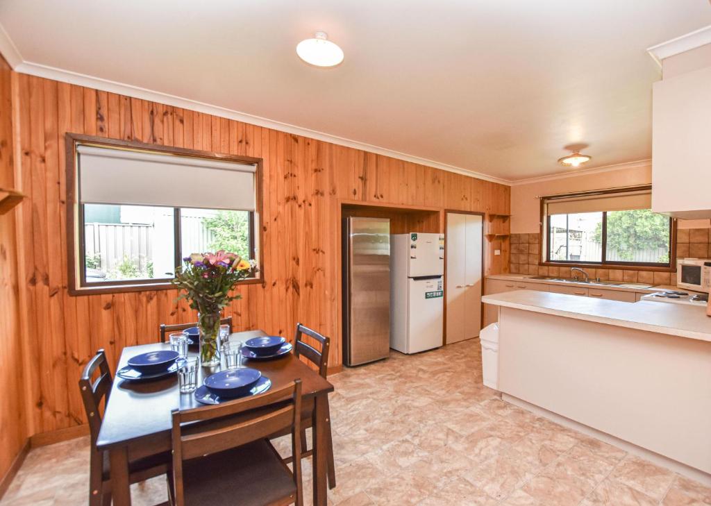 a kitchen with wood paneling and a table and chairs at Jamieson Cottage in Myrtleford