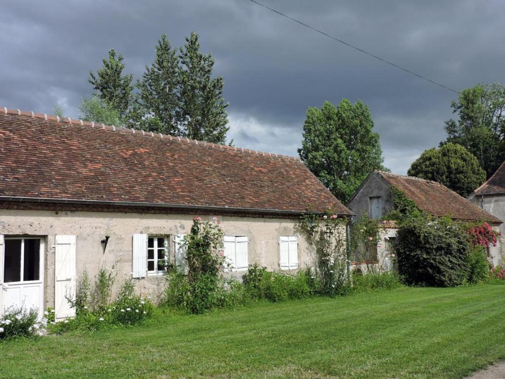 uma antiga casa de pedra com um jardim de relva em Gîte Treteau, 2 pièces, 2 personnes - FR-1-489-64 em Tréteau