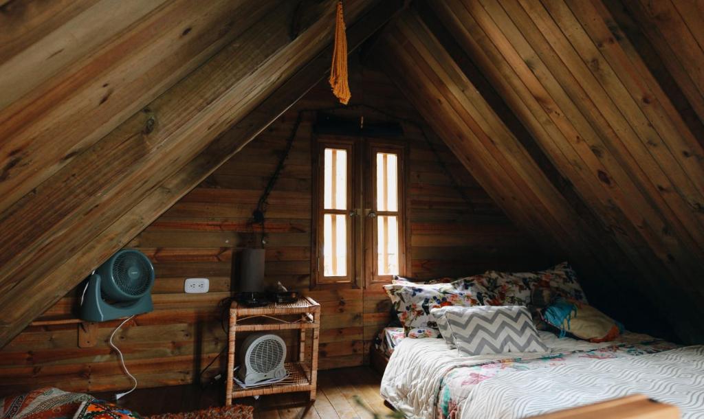 - une chambre avec un lit et une fenêtre dans une cabine dans l'établissement Cabañas Sinduly Bed & Breakfast, à Sopó