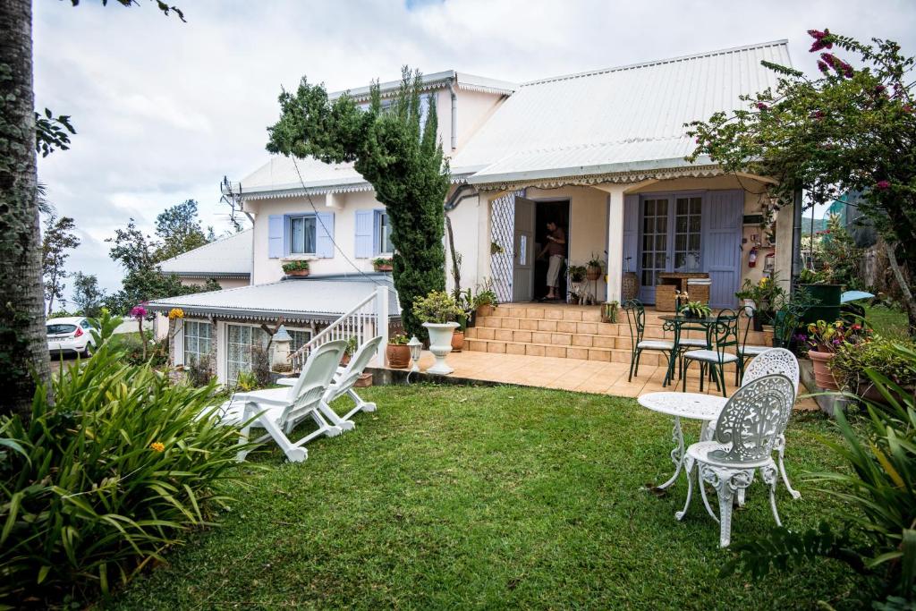 una casa con un patio con sillas y mesas en ORKY-MEL, en Petite Île