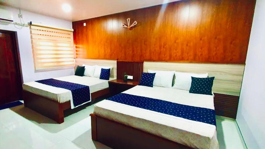 1 Schlafzimmer mit 2 Betten mit blauer und weißer Bettwäsche in der Unterkunft Hotel SU kataragama in Kataragama