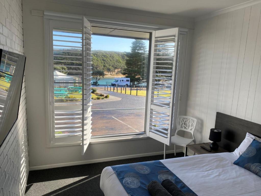 a bedroom with a window with a view of a street at Southern Ocean Motor Inn in Port Campbell