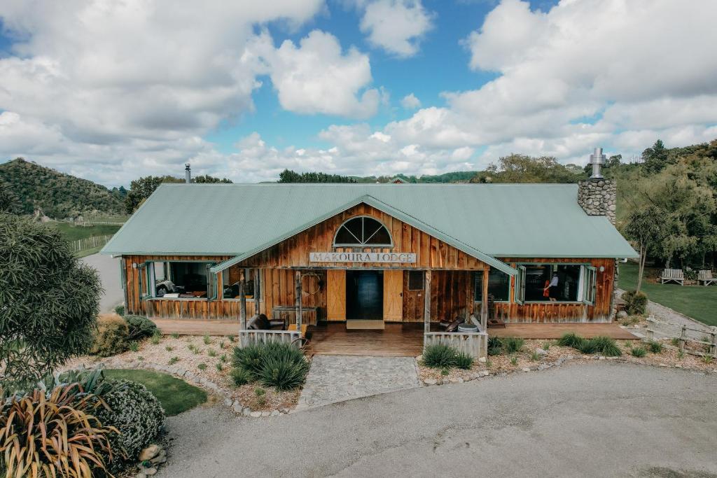 a large wooden building with a green roof at Makoura Lodge in Apiti