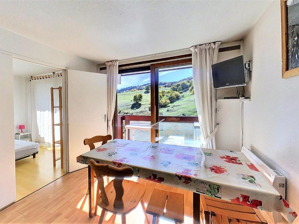 un salon avec une table et une grande fenêtre dans l'établissement Appartement lumineux au pied des pistes avec balcon, accès piscine et toutes commodités - FR-1-267-239, à Villarembert