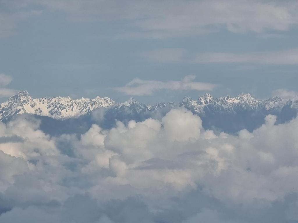 uma vista aérea de uma montanha coberta de neve com nuvens em Kheychun homestay em Darjeeling