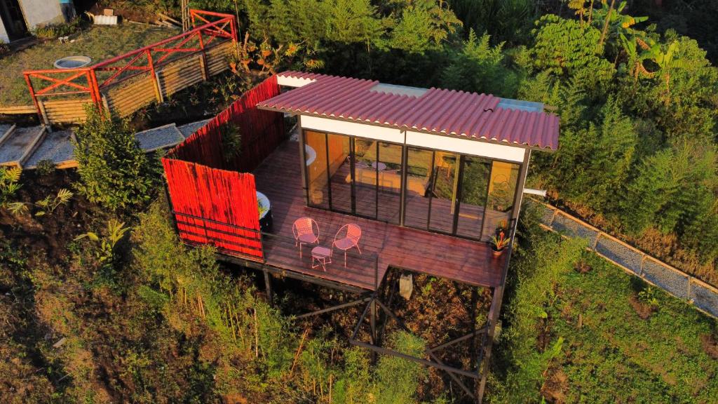 a model train with a house on a hill at La Paloma Glamping in Palestina