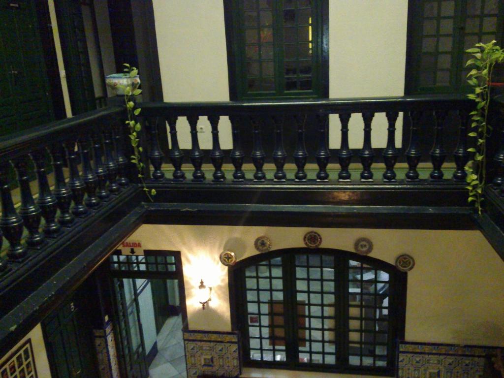 - un bâtiment avec une balustrade noire et un balcon dans l'établissement Hotel Cervantes, à Badajoz