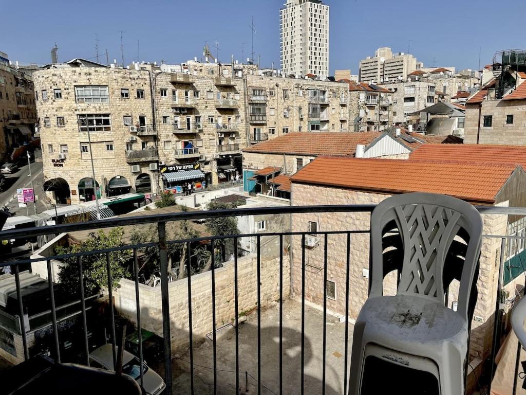 uma cadeira numa varanda com vista para a cidade em Gorgeous duplex in heart of Jerusalem em Jerusalém