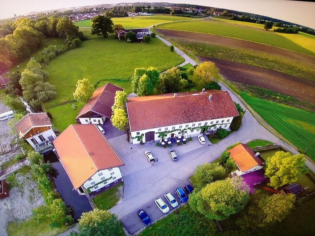 eine Luftansicht eines Gebäudes mit vor dem Haus geparkt in der Unterkunft Pension Poschmühle in Traunreut