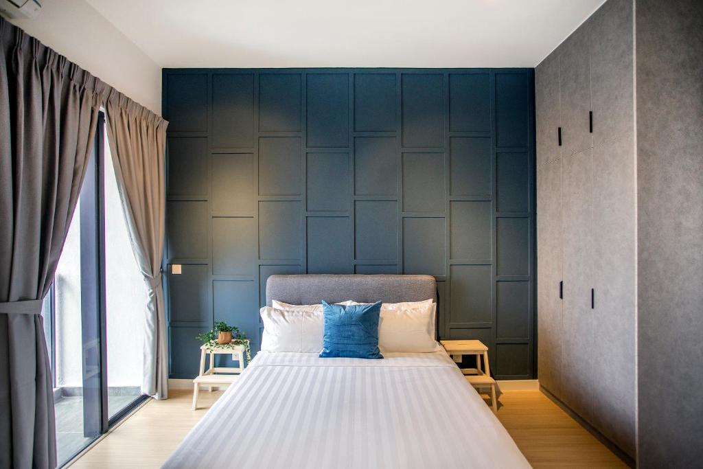 a bedroom with a large bed with a blue wall at Continew Residence KL CoBNB in Kuala Lumpur