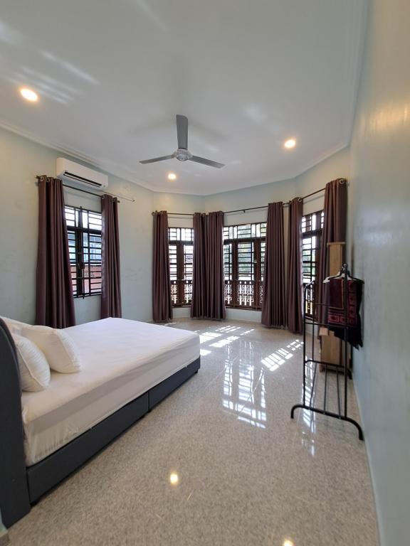 um quarto com uma cama e algumas janelas em ZN Homestay Gong Badak em Kampong Pengkalan Maras
