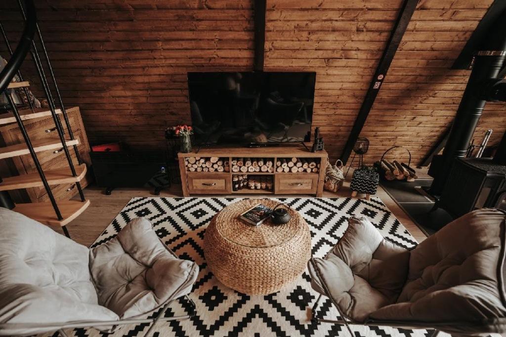 a living room with two chairs and a flat screen tv at Nordik Cabin - Aframe with 2 bedrooms in Mărişel