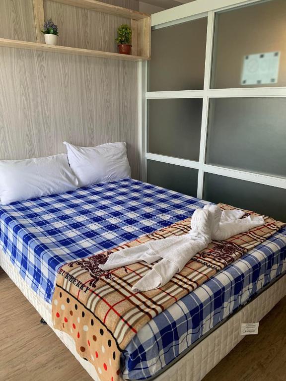 a bedroom with a bed with a blue and white blanket at Tagaytay Prime Residences with FREE wifi netflix light cooking viewdeck in Tagaytay