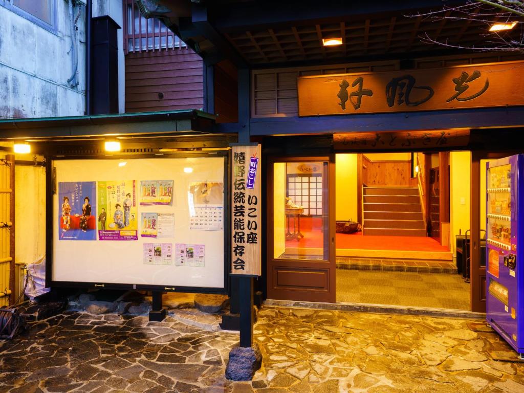 un edificio con una señal delante de una puerta en Ureshino Onsen Kotobukiya, en Ureshino