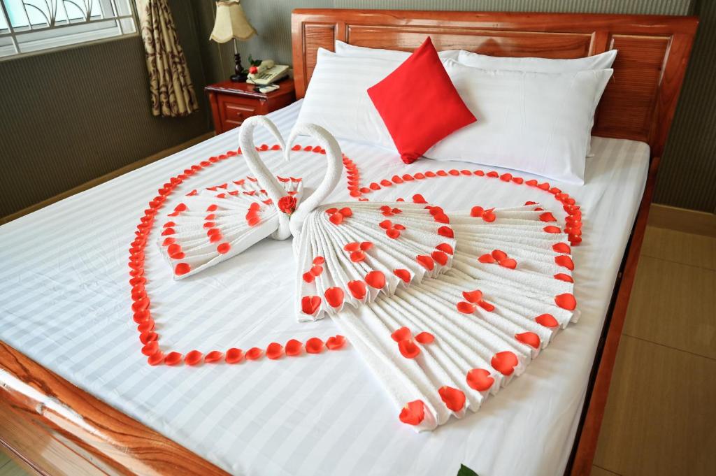 uma cama com um coração feito de contas vermelhas em Quang Hoa Airport Hotel em Ho Chi Minh