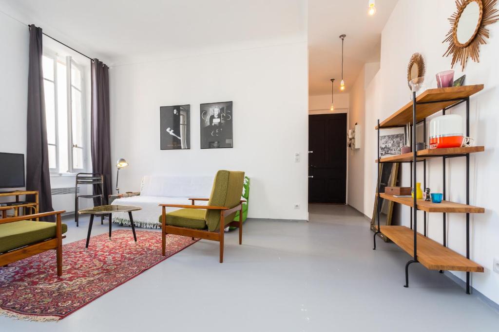 un salon avec un canapé, une table et des chaises dans l'établissement Appartement le Fighiéra, à Nice