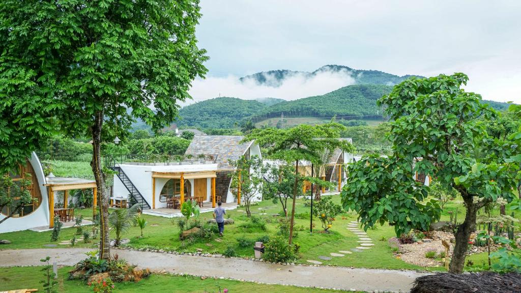 a house with a garden and mountains in the background at Bavi Myan Maison in Yên Cư