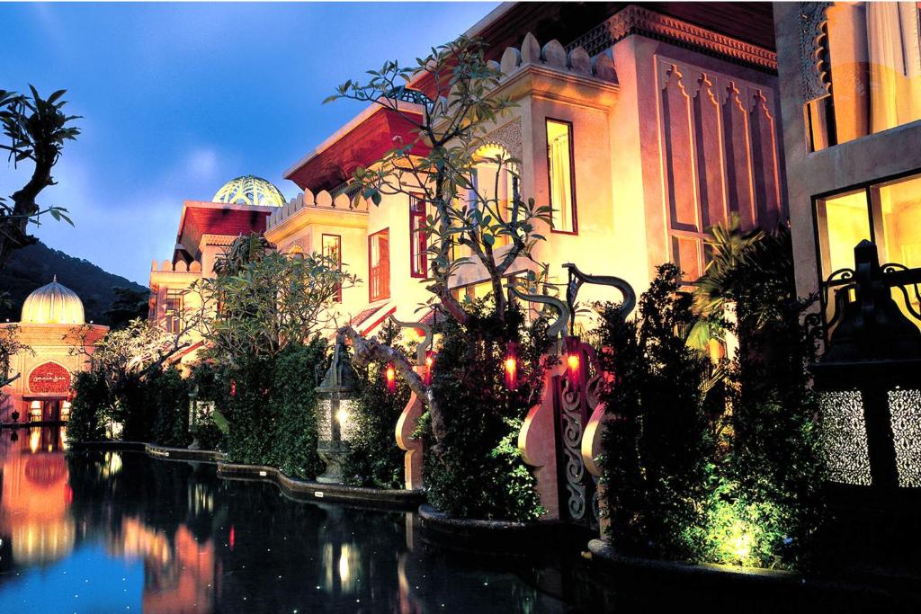 a building with trees and lights in front of a building at The Baray Villa by Sawasdee Village in Kata Beach