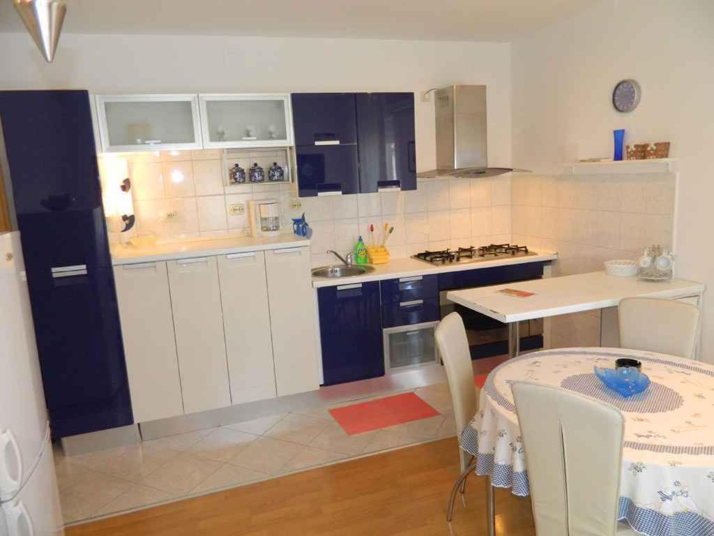 a kitchen with white cabinets and a table with a dining room at Apartment in Valbandon - Istrien 27864 in Valbandon