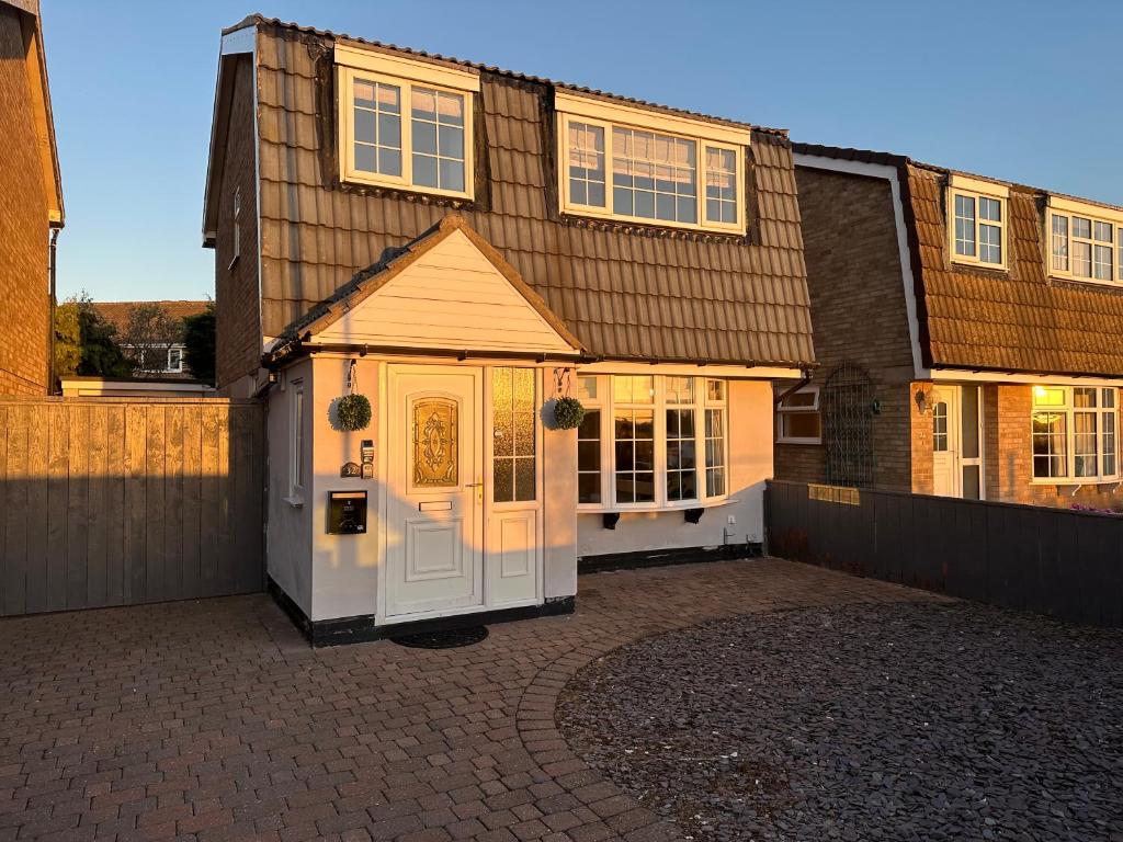 een huis met een witte deur en een hek bij Stunning 3 Bedroom Dutch barn cottage with parking in Stockton-on-Tees