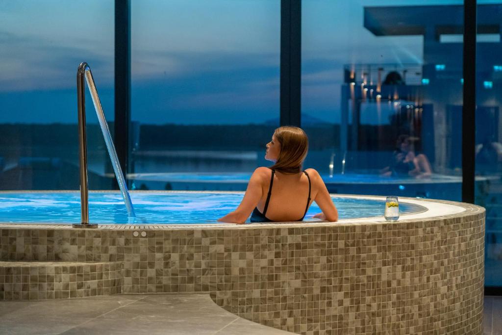 ブライラにあるAlma Health & Spa Retreatのプールに座っている女性