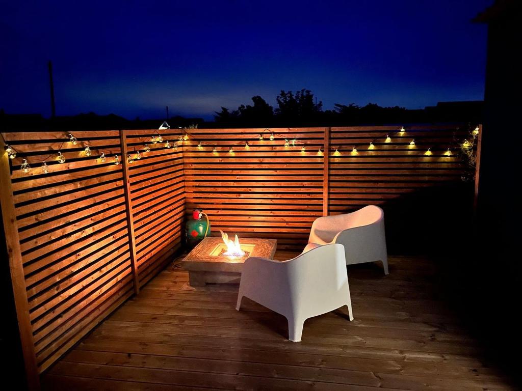 a patio with two chairs and a table and lights at Shepherds Beachhouse in Pagham