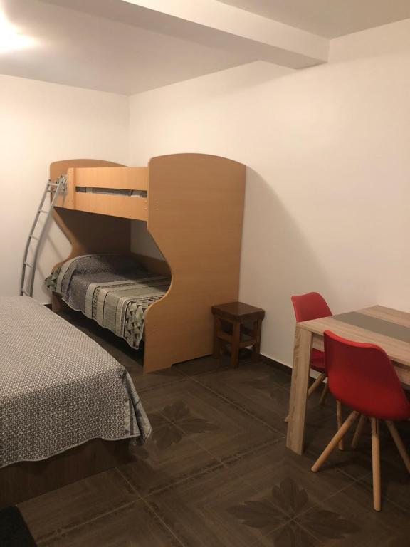 a bedroom with a bunk bed and a table and a bed at Apartments Tonka in Zadar