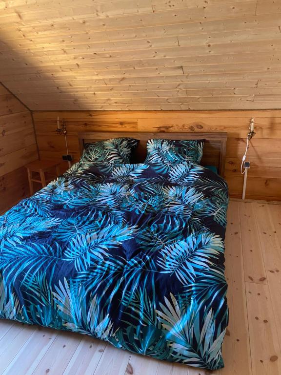 Bett mit blauer Decke in einem Zimmer in der Unterkunft Gabel&Jurgen in Mirsk