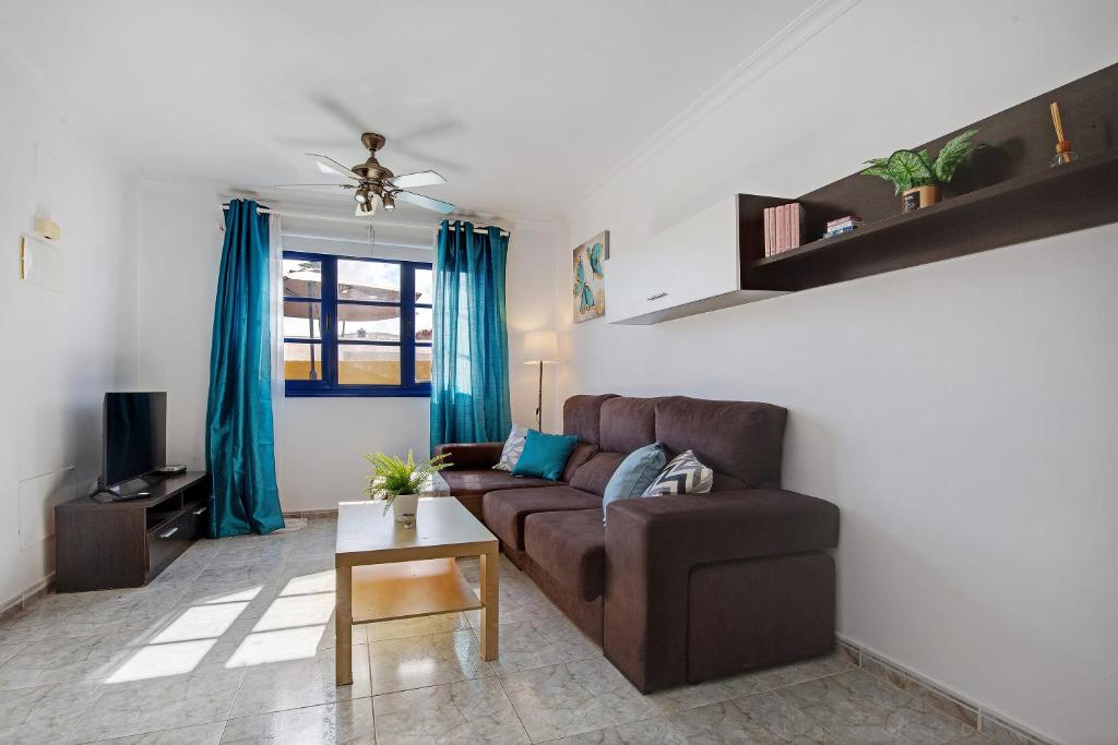 salon z brązową kanapą i stołem w obiekcie Apartamento Tanzanita w mieście Costa Calma