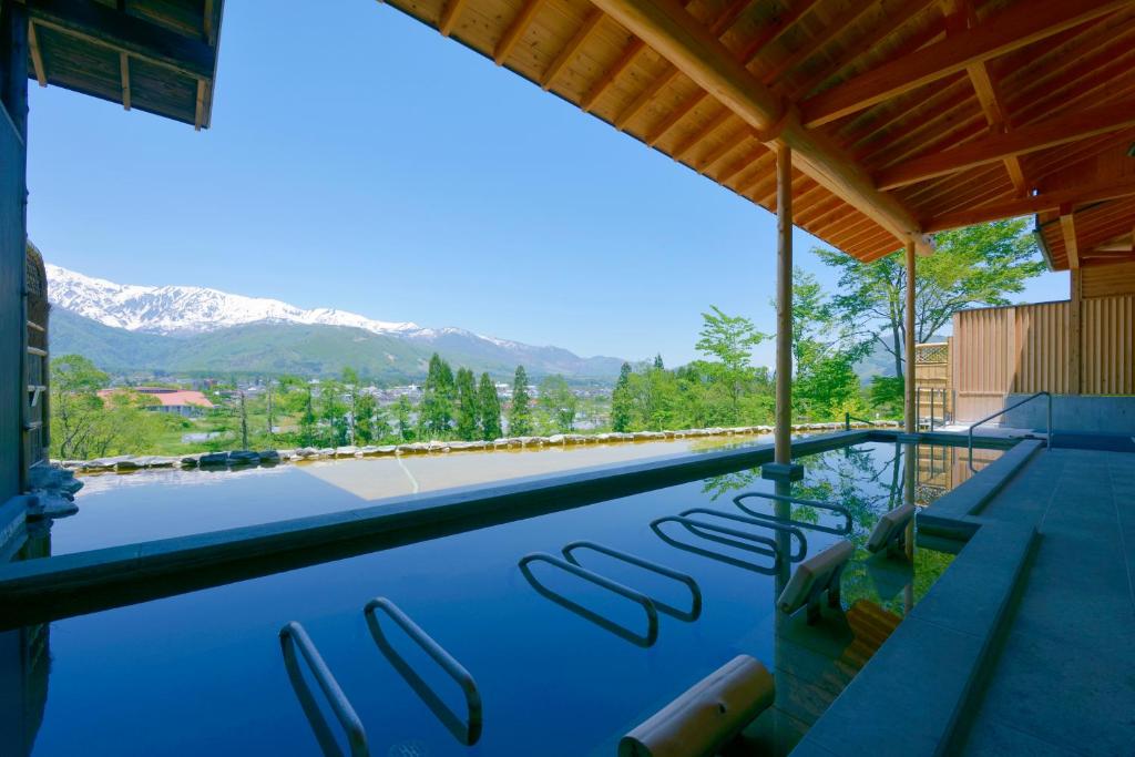 a swimming pool with a view of the mountains at Hakuba Highland Hotel in Hakuba