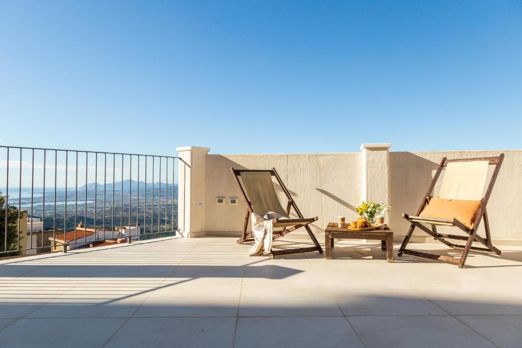 a balcony with two chairs and a table on a building at Monte Forru in Baunei