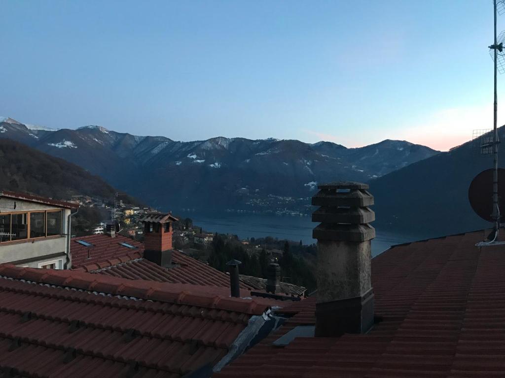 uitzicht vanaf het dak van een gebouw met bergen op de achtergrond bij Casa di borgo vista lago in Valsolda