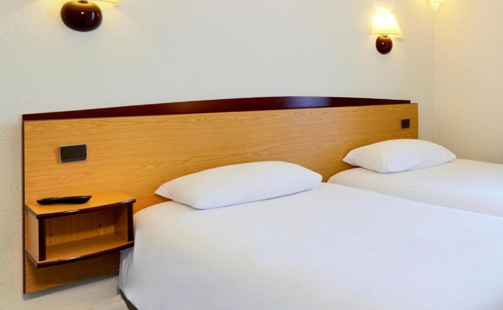 Postel nebo postele na pokoji v ubytování Kyriad Direct Le Bourget Gonesse