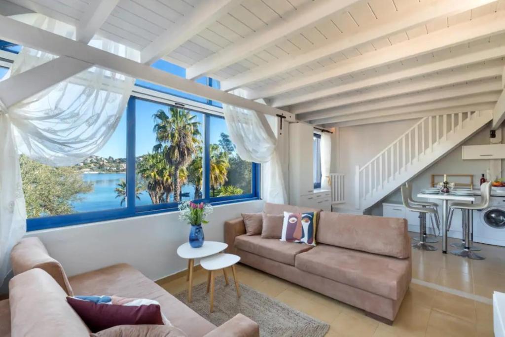 uma sala de estar com um sofá e uma mesa em Govino Bay Luxury Beach Loft Apartment em Danilia